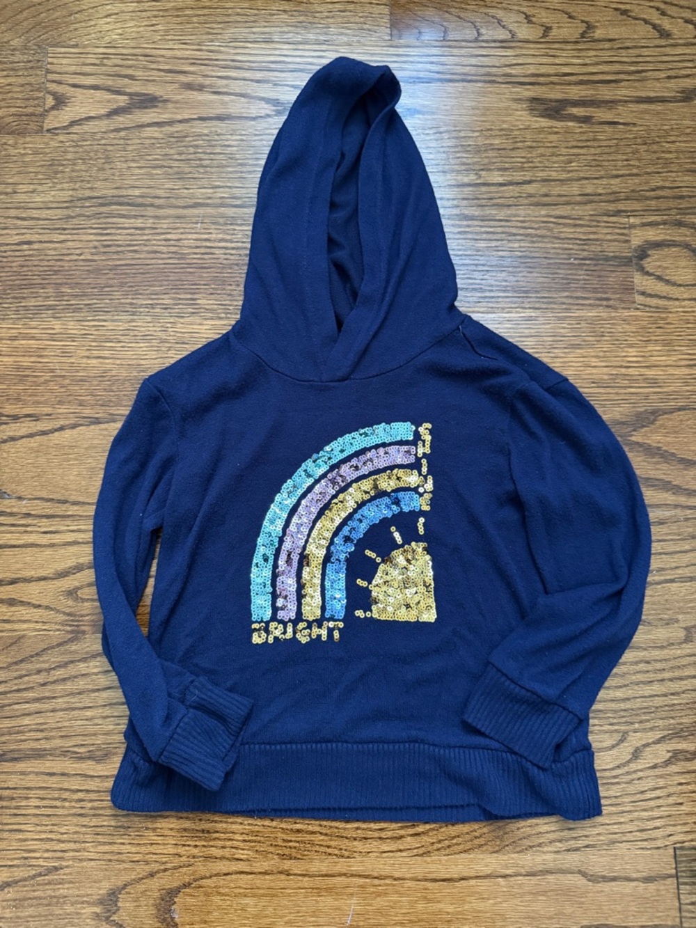 Rumi + Ryder navy pullover sweater with yellow tag detail